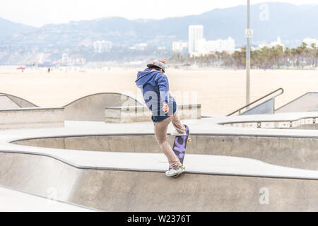 LOS ANGELES, CALIFORNIA, STATI UNITI D'America - 11 Maggio 2019: rampe in calcestruzzo e palme presso la popolare spiaggia di Venice skate park a Los Angeles in California Foto Stock