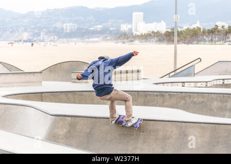 LOS ANGELES, CALIFORNIA, STATI UNITI D'America - 11 Maggio 2019: rampe in calcestruzzo e palme presso la popolare spiaggia di Venice skate park a Los Angeles in California Foto Stock