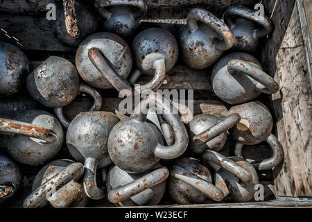 Molti pesi kettlebells background in palestra all'aperto. Texture di stell pesi liberi per il sollevamento pesi sdraiato sul pavimento al centro fitness per la formazione incrociata. Foto Stock