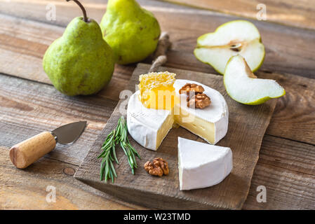 Formaggio Camembert con pere e noci sul pannello di legno Foto Stock