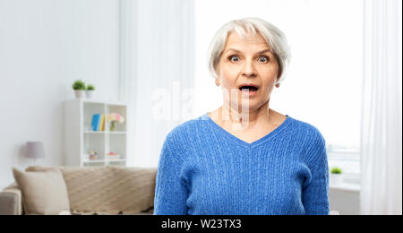Scioccato senior donna con la bocca aperta a casa Foto Stock