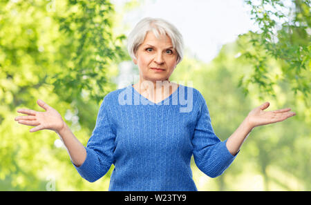 Senior donna non avente alcuna idea e scrollare Foto Stock