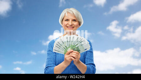 Senior donna con centinaia di euro banconote denaro Foto Stock