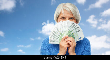 Senior donna con centinaia di euro banconote denaro Foto Stock