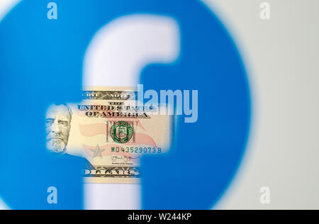 Dollaro visto attraverso il logo trasparente di Facebook su una brochure stampata. Foto concettuale per Facebook Libra - nuovo facebook denaro. Foto Stock