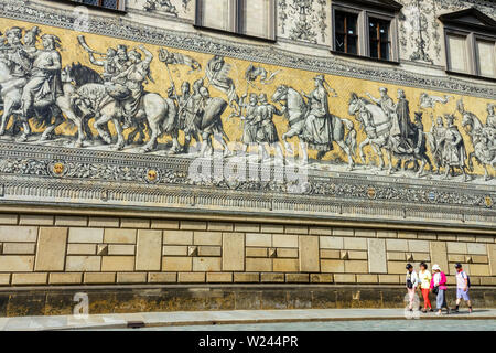 Turisti asiatici passando sotto Fürstenzug, la Processione dei Principi sulla parete, Augustusstrasse Altstadt Dresda Città Vecchia Germania Foto Stock