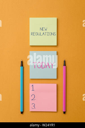 La scrittura della nota mostra nuovi regolamenti. Il concetto di business per regolamento controllo dell'attività di solito utilizzato per le regole. Vista frontale colorata nota appiccicosa t Foto Stock