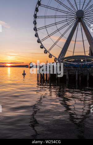 Il Seattle grande ruota è una ruota panoramica sul lungomare al Pier 57, sovrastante la baia di Elliot, con una vista fantastica del Puget Sound e il tramonto estivo Foto Stock