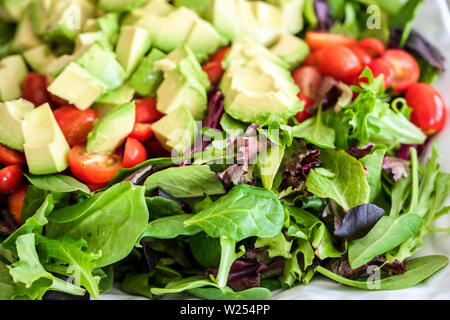 Nutriente low-calorie organic insalata di verdure fatta da foglie verdi e pomodoro e avocado condito con olio di oliva aiuterà il corpo di ottenere il necess Foto Stock