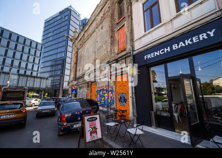 Bucarest, Romania - Luglio 07, 2019: un alto e moderno edificio, chiamato il marchio Tower, in contrasto con alcuni vecchi edifici situati in una strada a Bucha Foto Stock