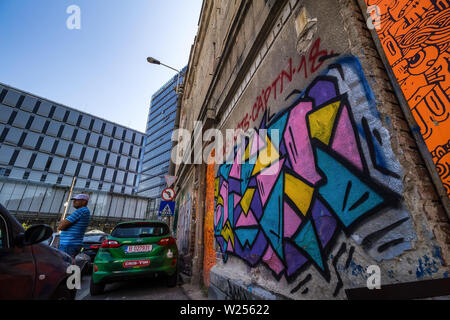 Bucarest, Romania - Luglio 07, 2019: un alto e moderno edificio, chiamato il marchio Tower, in contrasto con alcuni vecchi edifici situati in una strada a Bucha Foto Stock