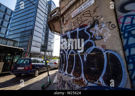 Bucarest, Romania - Luglio 07, 2019: un alto e moderno edificio, chiamato il marchio Tower, in contrasto con alcuni vecchi edifici situati in una strada a Bucha Foto Stock