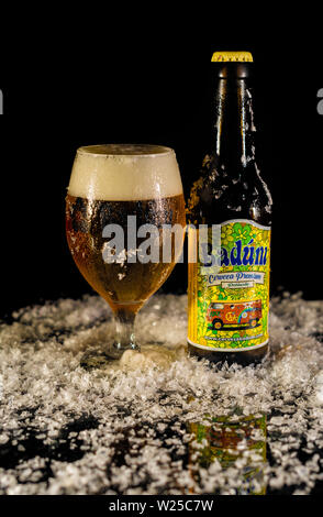 Peniscola, Castellon, Spagna, Maggio 08, 2019: Close up Badum una bottiglia di birra e schiuma di birra in un bicchiere. Foto Stock