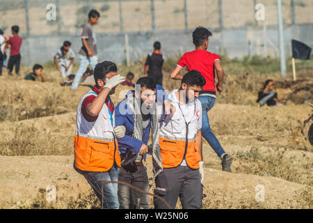 5 luglio 2019 - Gaza, Palestina. 05 luglio 2019. Dimostranti palestinesi scontro con le forze israeliane durante questo Venerdì di grande marzo di tornare nel rally di Malika area a est della città di Gaza. Migliaia di palestinesi aveva fatta convergere in differenti siti vicino alla frontiere Gaza-Israel per unirsi alla protesta. Alcuni dei manifestanti hanno lanciato sassi verso i soldati israeliani di stanza sull'altro lato della recinzione che hanno risposto con gas lacrimogeni e proiettili di ferire decine di dimostranti palestinesi. Dimostranti palestinesi hanno organizzato una grande Marcia di protesta di ritorno dal 30 marzo scorso anno Foto Stock