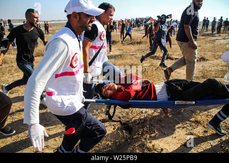 5 luglio 2019 - Gaza, Palestina. 05 luglio 2019. Dimostranti palestinesi scontro con le forze israeliane durante questo Venerdì di grande marzo di tornare nel rally di Malika area a est della città di Gaza. Migliaia di palestinesi aveva fatta convergere in differenti siti vicino alla frontiere Gaza-Israel per unirsi alla protesta. Alcuni dei manifestanti hanno lanciato sassi verso i soldati israeliani di stanza sull'altro lato della recinzione che hanno risposto con gas lacrimogeni e proiettili di ferire decine di dimostranti palestinesi. Dimostranti palestinesi hanno organizzato una grande Marcia di protesta di ritorno dal 30 marzo scorso anno Foto Stock