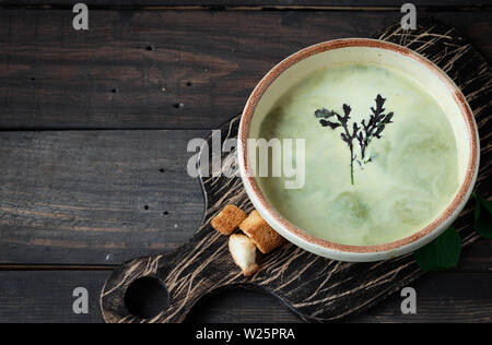 Zuppa cremosa purea di spinaci su sfondo scuro Foto Stock