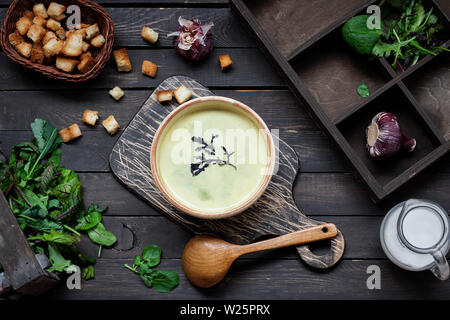 Zuppa cremosa purea di spinaci su sfondo scuro Foto Stock