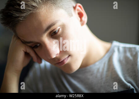 Close up della triste e depresso ragazzo adolescente a casa Foto Stock