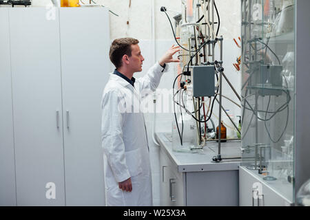 Scienziato conduce esperimenti di chimica in laboratorio Foto Stock