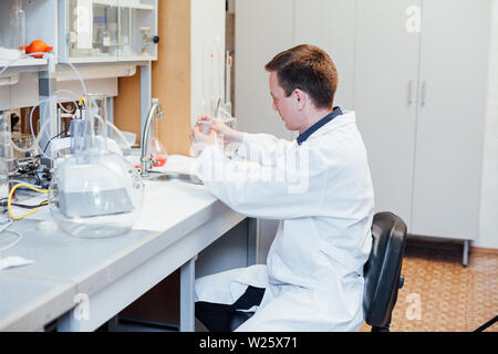 Scienziato conduce esperimenti di chimica in laboratorio Foto Stock