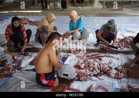 Musulmana di affettare la carne di capra quando l'Eid Al Adha a Semarang, Indonesia Foto Stock