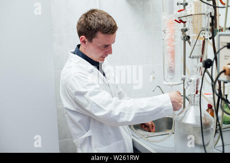 Scienziato conduce esperimenti di chimica in laboratorio Foto Stock