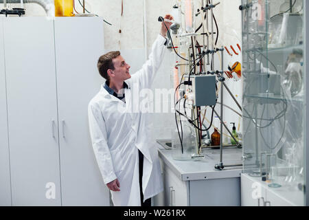 Scienziato conduce esperimenti di chimica in laboratorio Foto Stock