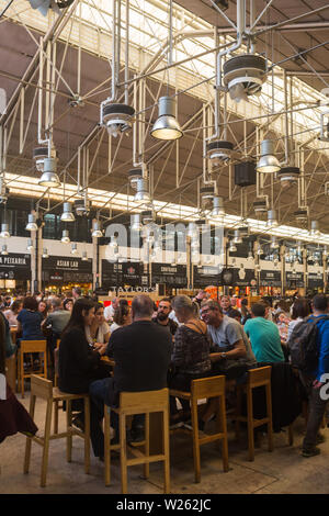 Interior food court del tempo fuori mercato nel vecchio Mercardo da Ribeira, Lisbona, Portogallo occupato con le persone che si godono la vasta gamma di prodotti alimentari offerti Foto Stock