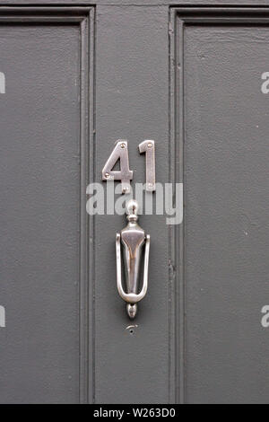 Casa numero 41 con il forty-one in cifre di metallo su una tavola di legno porta anteriore e una porta elegante respingente Foto Stock