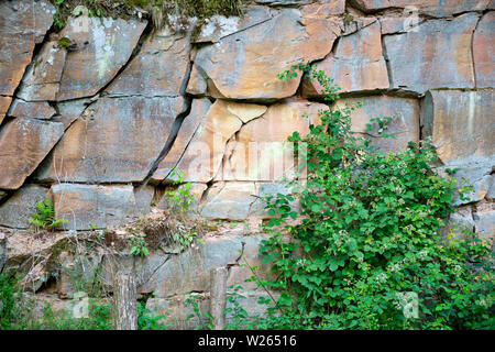 Una parete con strati di rotture di pietra arenaria rossa in un antico pozzo in pietra in Spessart in Germania Foto Stock