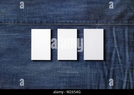 Tre blank business cards su sfondo denim. Il Branding mockup. Lay piatto. Foto Stock