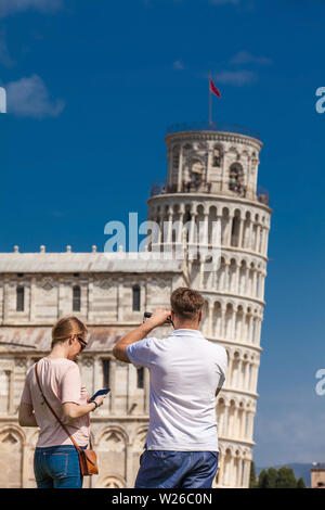 PISA, Italia - Aprile 2018: giovane coppia di turisti di fotografare la famosa Torre Pendente di Pisa Foto Stock