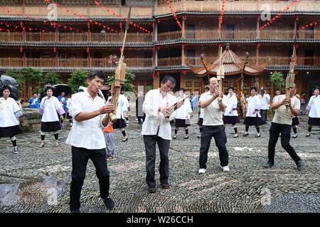 (190706) -- QIANDONGNAN, Luglio 6, 2019 (Xinhua) -- la gente di Dong gruppo etnico dance lungo con Lusheng, una zampogna di strumento a fiato, in Leli township di Rongjiang County, a sud-ovest della Cina di Guizhou, Luglio 6, 2019. La popolazione locale di Dong gruppo etnico frequentare la raccolta per contrassegnare il Festival Xiangsi. (Foto di Yang Chengli/Xinhua) Foto Stock