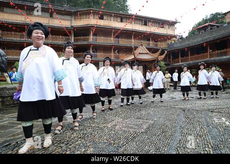 (190706) -- QIANDONGNAN, Luglio 6, 2019 (Xinhua) -- la gente di Dong gruppo etnico dance lungo con Lusheng, una zampogna di strumento a fiato, in Leli township di Rongjiang County, a sud-ovest della Cina di Guizhou, Luglio 6, 2019. La popolazione locale di Dong gruppo etnico frequentare la raccolta per contrassegnare il Festival Xiangsi. (Foto di Yang Chengli/Xinhua) Foto Stock