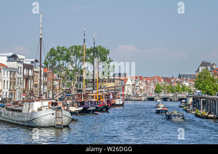 Leiden, Paesi Bassi, 18 Maggio 2019: vista dal ponte di Rembrandt attraverso Galgewater canal verso la città vecchia con la sua storica chiatte e case, barche Foto Stock