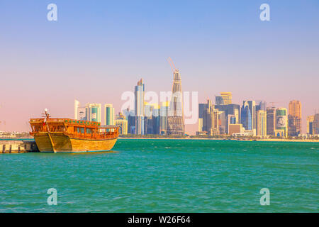 Doha, Qatar - 20 febbraio 2019:tradizionale sambuco e dal lungomare di Doha West Bay skyline sullo sfondo con il Qatar International Exhibition Centre, Doha Foto Stock