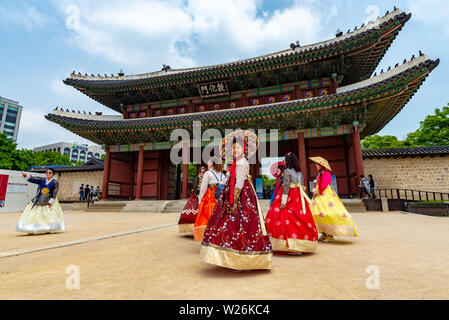 SEOUL, Corea del Sud - 1 giugno 2019: un gruppo di donne nel tradizionale costume coreano sono in procinto di entrare nel Palazzo di Changdeokgung attraverso il cancello principale Foto Stock