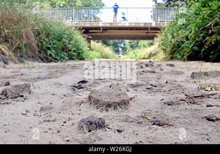 Dinslaken, Germania. 06 Luglio, 2019. Un uomo guarda da un ponte a secco di alveo del Rotbach. Credito: Martin Gerten/dpa/Alamy Live News Foto Stock