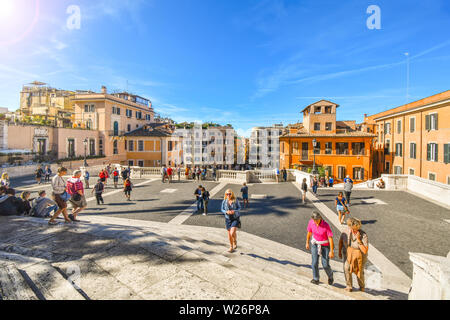 Il turista a godere di una posizione soleggiata dire sulla Scalinata di piazza di Spagna con la Piazza di Spagna dietro nel centro storico di Roma, Italia. Foto Stock