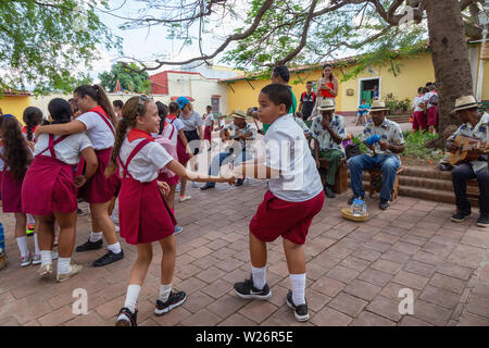 Trinidad, Cuba - Giugno 6, 2019: Gli studenti sono a ballare la musica dal vivo per le strade di una piccola città cubane durante una vivace giornata di sole. Foto Stock