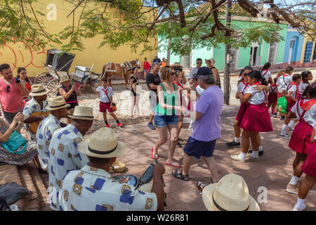 Trinidad, Cuba - Giugno 6, 2019: la gente ballare con la musica dal vivo per le strade di una piccola città cubane durante una vivace giornata di sole. Foto Stock