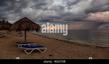 Bella vista panoramica di una spiaggia sabbiosa, Playa Ancon, sul Mar dei Caraibi in Triniday, Cuba, durante un nuvoloso e piovoso sunrise. Foto Stock