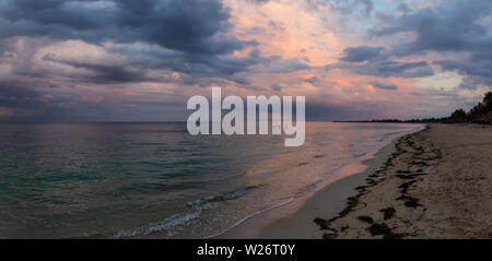 Bella vista panoramica di una spiaggia sabbiosa, Playa Ancon, sul Mar dei Caraibi in Triniday, Cuba, durante un nuvoloso e piovoso sunrise. Foto Stock