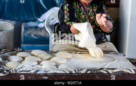 Close up della vecchia donna araba mani fresche per impastare la pasta per pane Taboon o Lafah è un Middle Eastern flatbread anche chiamato lafa o irachena pita. Foto Stock