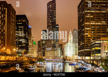 Stati Uniti d'America, Chicago, Illinois. Maggio 10, 2019. L'orario del tramonto. Chicago city grattacieli illuminati e Trump Tower in serata. Riflessioni sul fiume canal Foto Stock