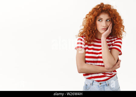 Triste unione redhead curly donna magra palm testa noia dispiace guardare a sinistra geloso seduta ufficio noioso sogno permanente di partito sconvolto infelice striped t-sh Foto Stock