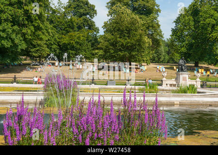 Londra Inghilterra - Luglio 15 2013; ornamentali Giardini Italiani in Kensington Gardens con la statua in bronzo di Jenner e la gente a prendere il sole in sedie a sdraio sul Foto Stock