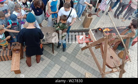 Nizhny Novgorod, Russia - Giugno 12, 2019: Giorno di Indipendenza. Città delle vacanze. Giovani fare monete, la fusione del metallo, stampo e lavorare su una incudine. La Russia Foto Stock