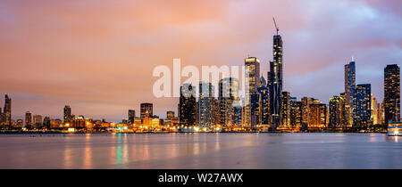 Sullo skyline di Chicago panorama, l'orario del tramonto. Vista panoramica della città di Chicago waterfront grattacieli illuminati, cielo molto nuvoloso in serata Foto Stock