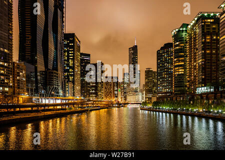 Chicago city cityscape, l'orario del tramonto. Chicago city grattacieli illuminati di sera. Riflessioni sul fiume canal Foto Stock